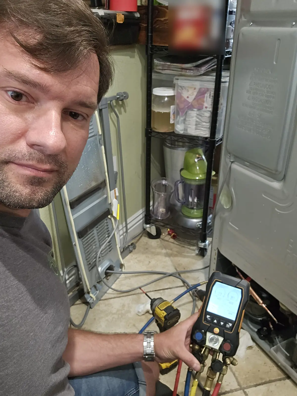 Roman Abysov, owner of Same Day Appliance Repair, diagnosing a refrigerator sealed system in Los Angeles