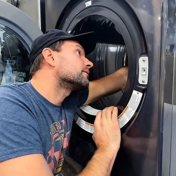 Professional technician repairing a refrigerator in a home kitchen